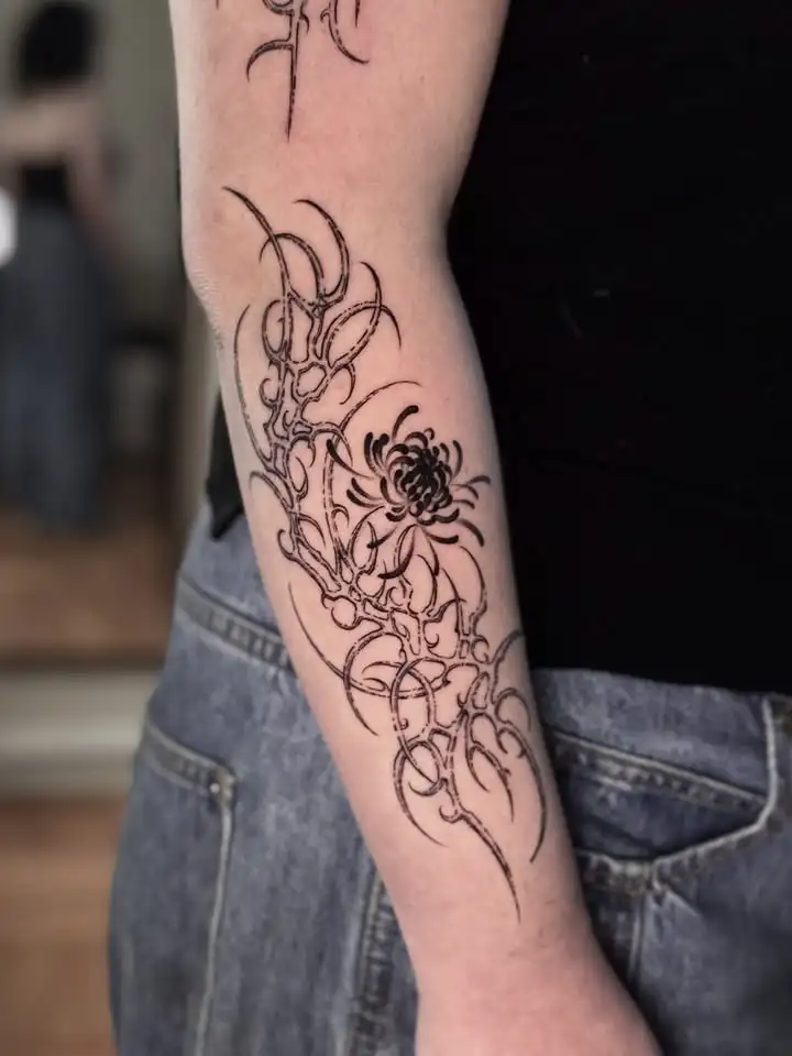 Composición neotribal y floral sobre un brazo, publicada por Gata Astuta Tattoo